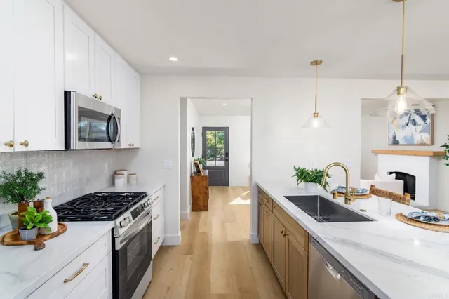 a kitchen with granite countertop a sink stove and cabinets