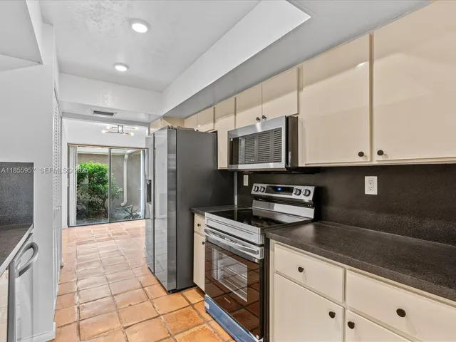 a kitchen with stainless steel appliances granite countertop a refrigerator and a sink