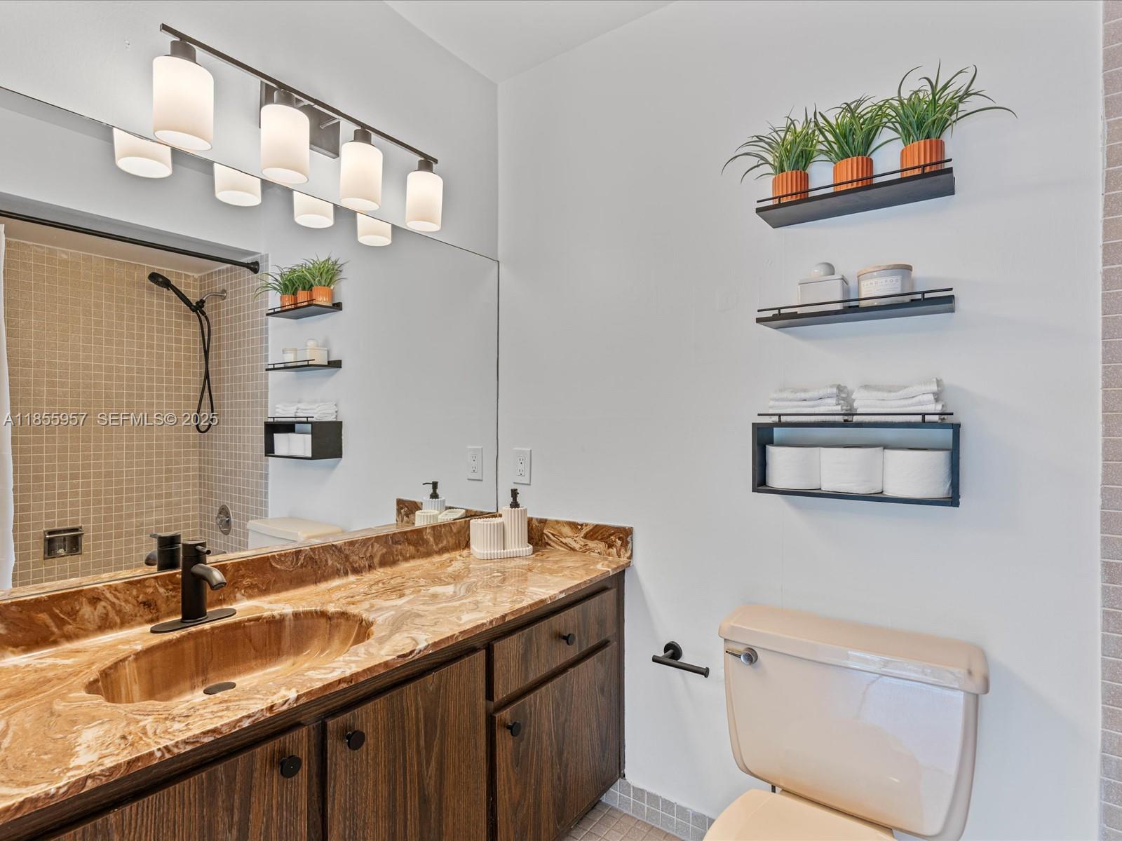 203 Bonnie Brae Way, Unit 34 Hollywood, FL 33021 - Photo 27 of 41 a bathroom with a sink a toilet and a mirror
