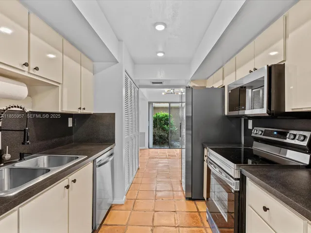 a kitchen with a sink stainless steel appliances and white cabinets