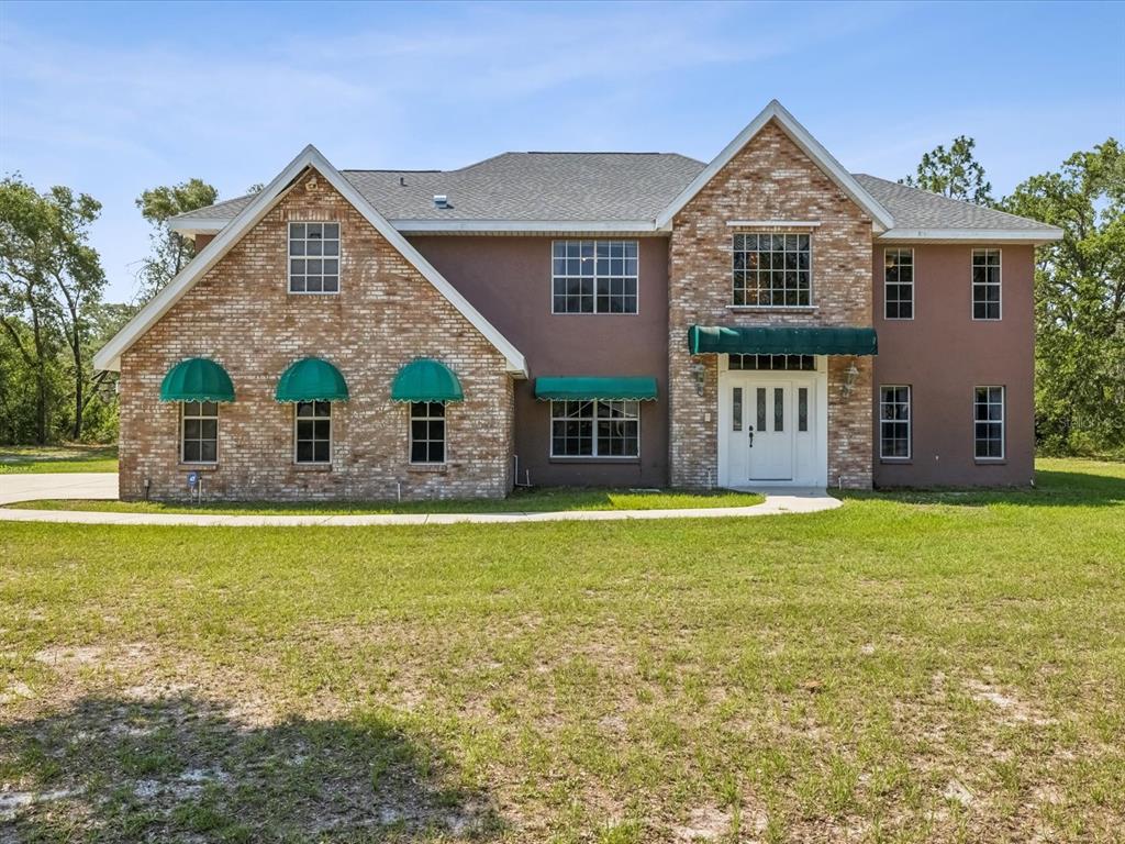 15420 Aubrey Avenue Spring Hill, FL 34610 - Photo 1 of 28 a front view of a house with a garden