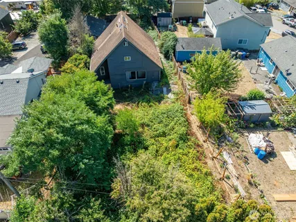 an aerial view of residential house with outdoor space and trees all around