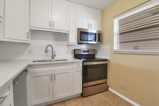 a kitchen with white cabinets and white appliances