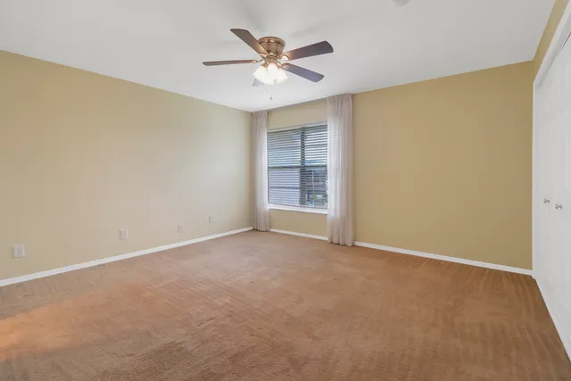 an empty room with closet and ceiling fan