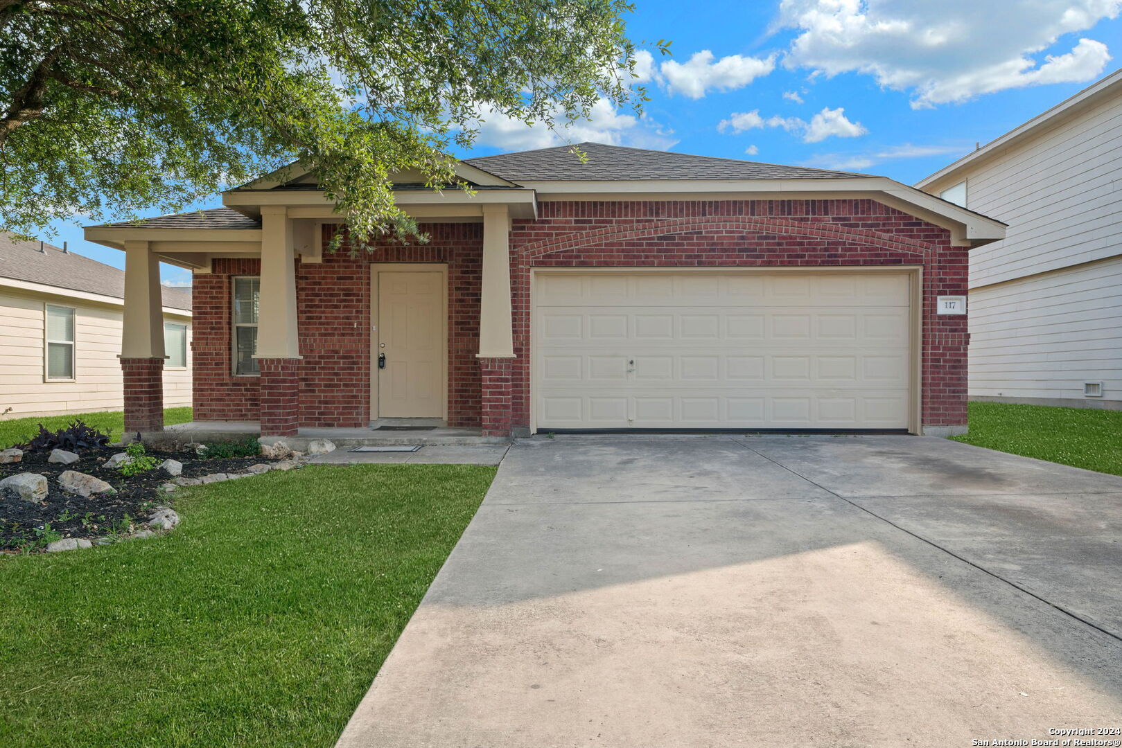 a front view of a house with a garden and plants