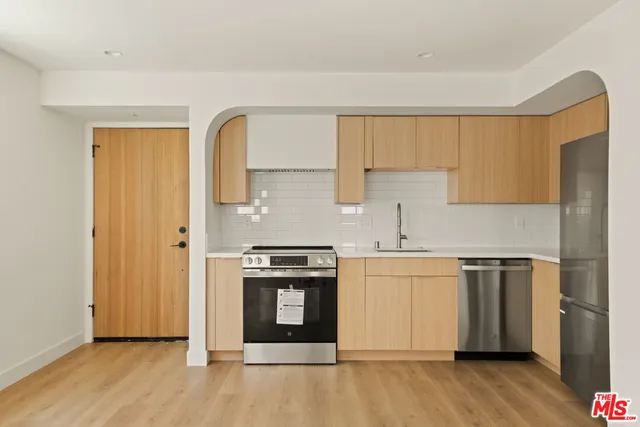 a kitchen with stainless steel appliances granite countertop a stove a sink and a refrigerator