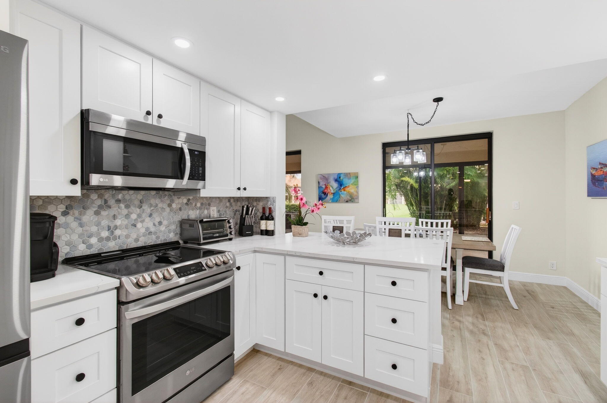 7727 La Mirada Drive Boca Raton, FL 33433 - Photo 22 of 91 a kitchen with white cabinets and stainless steel appliances