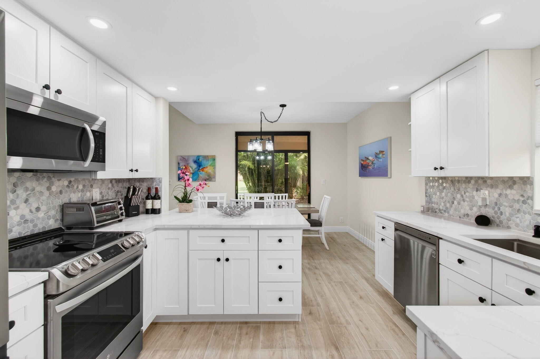 7727 La Mirada Drive Boca Raton, FL 33433 - Photo 27 of 91 a kitchen with stainless steel appliances a sink stove and cabinets