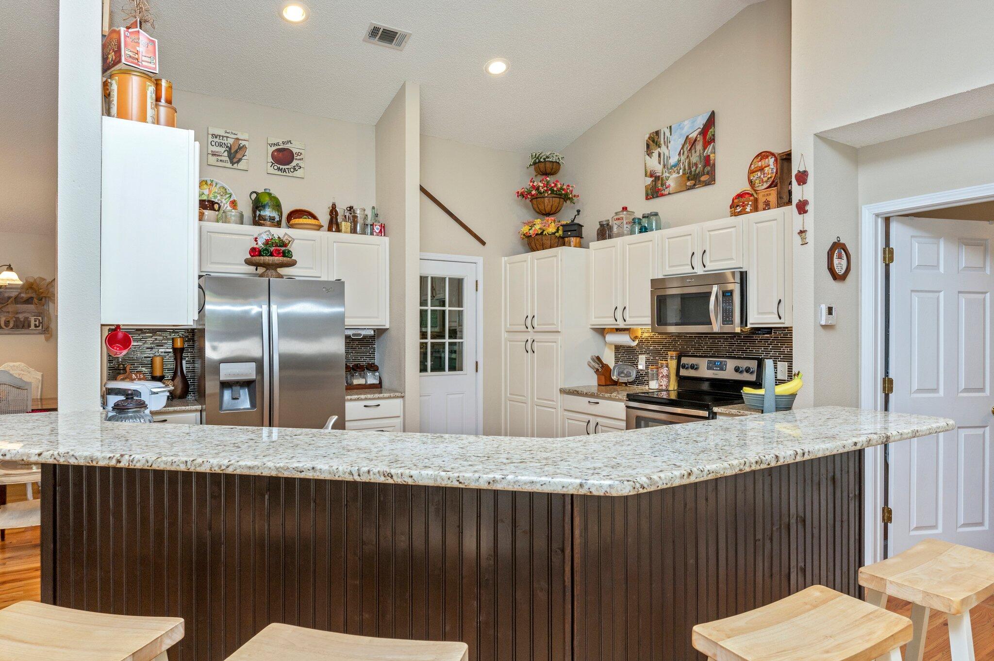 1084 Reeves Road Baker, FL 32531 - Photo 18 of 37 a kitchen with stainless steel appliances granite countertop a sink refrigerator and microwave