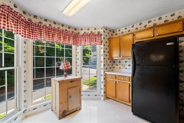a view of a refrigerator and a window in the room