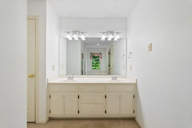 a bathroom with a double vanity sink and a mirror