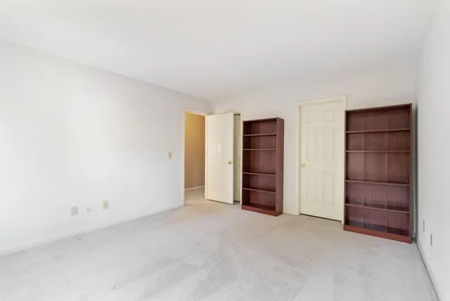 an empty room with closet and windows
