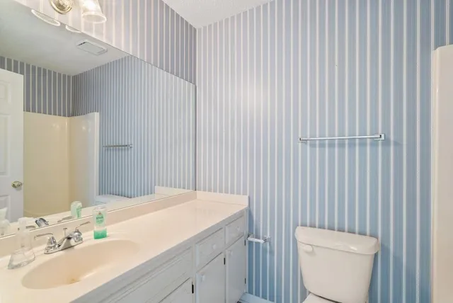 a bathroom with a sink a toilet and shower curtain