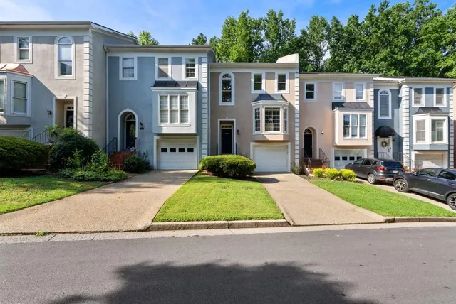 a front view of a house with yard and green space