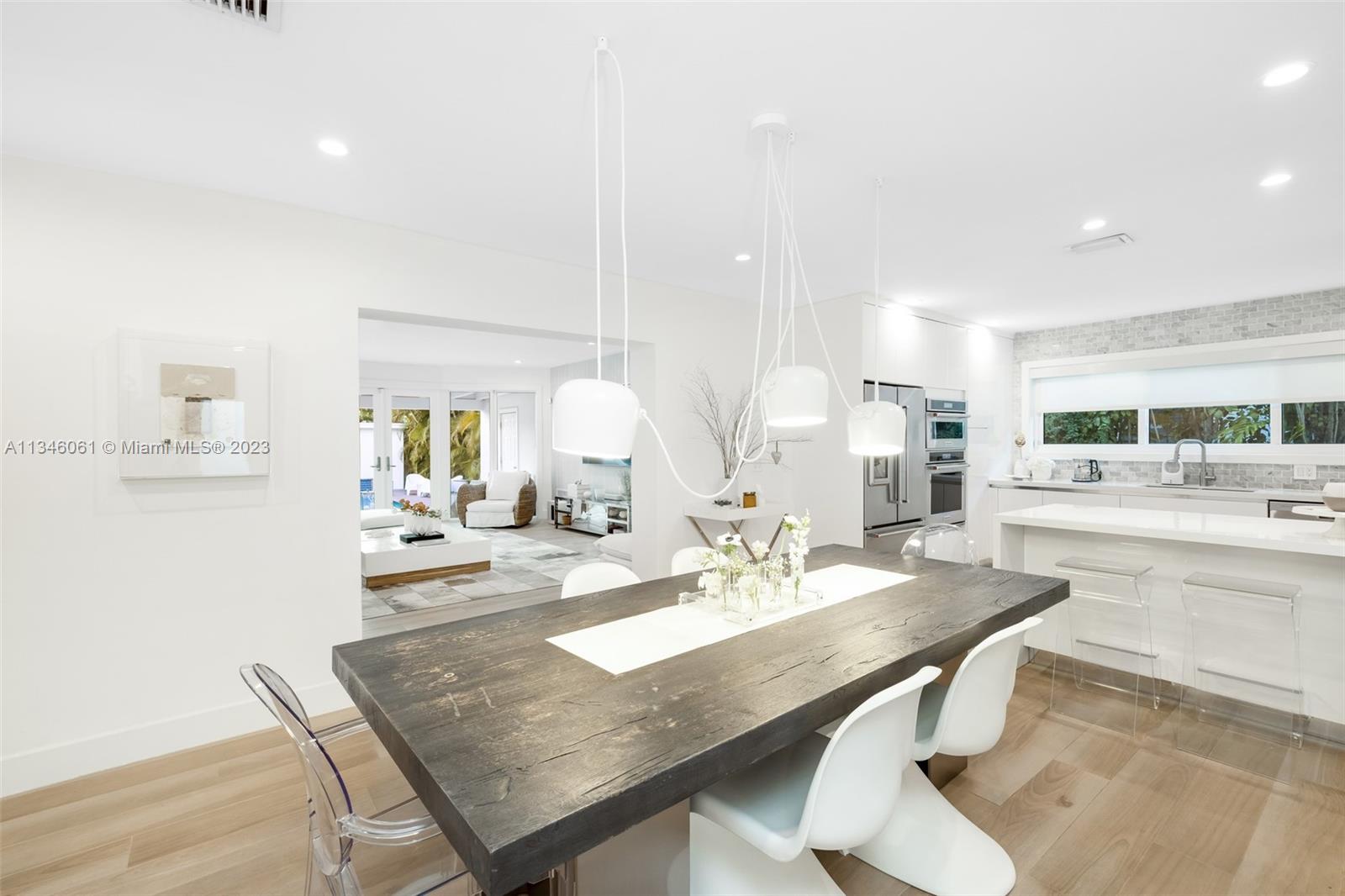 730 Southwest 26th Road Miami, FL 33129 - Photo 13 of 34 a dining hall with stainless steel appliances a dining table and chairs with wooden floor