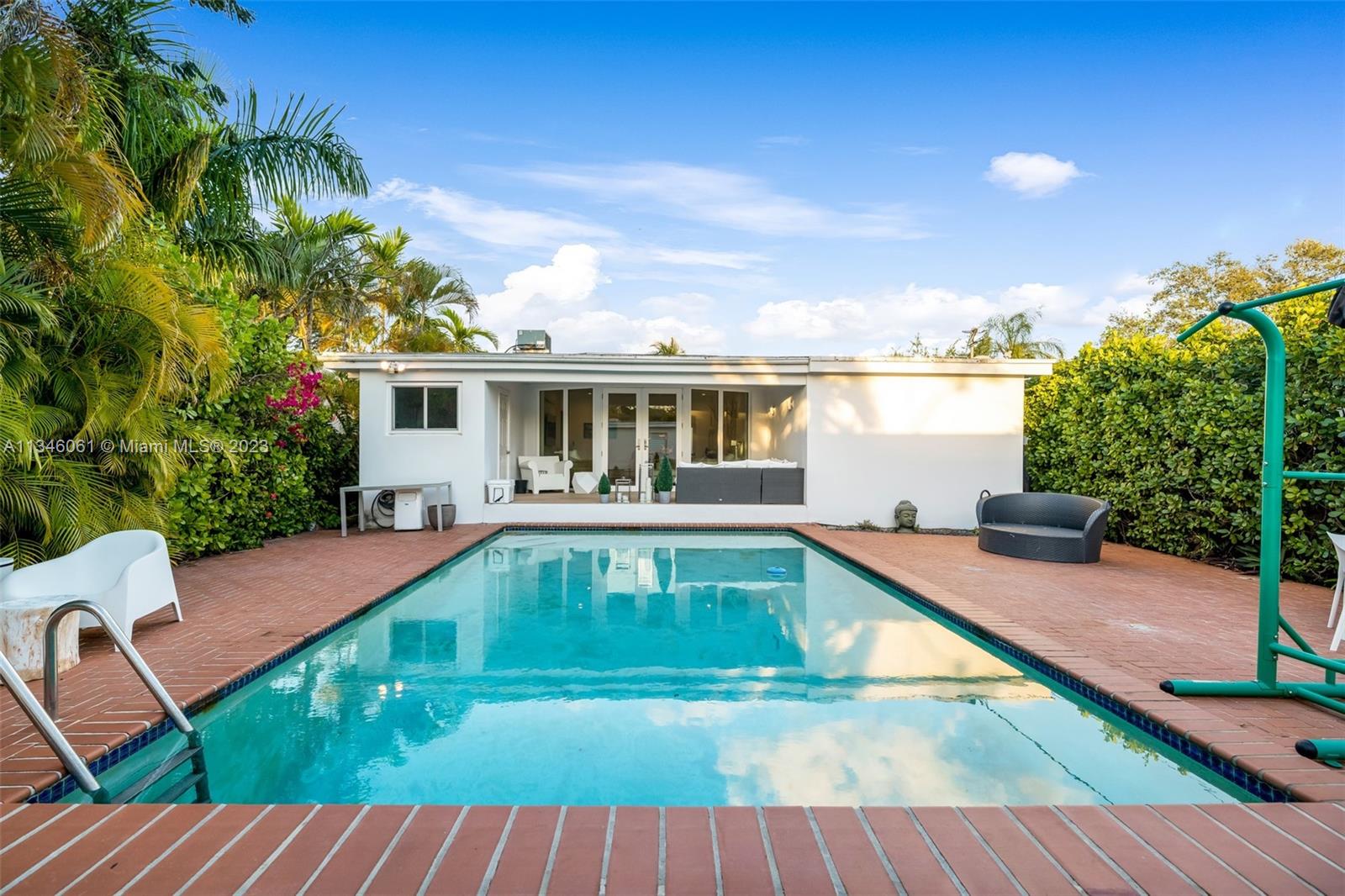 730 Southwest 26th Road Miami, FL 33129 - Photo 22 of 34 a view of a house with pool fire pit a patio and a garden