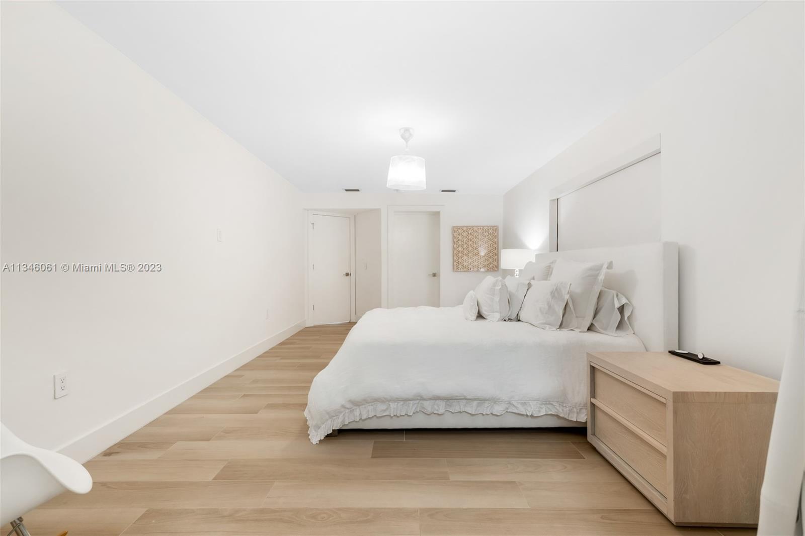 730 Southwest 26th Road Miami, FL 33129 - Photo 27 of 34 a spacious bedroom with a bed and a lamp