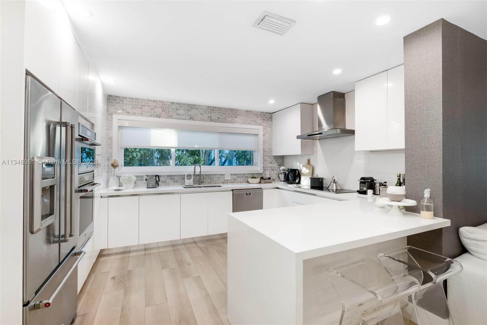 730 Southwest 26th Road Miami, FL 33129 - Photo 10 of 34 a kitchen with a sink a refrigerator and cabinets