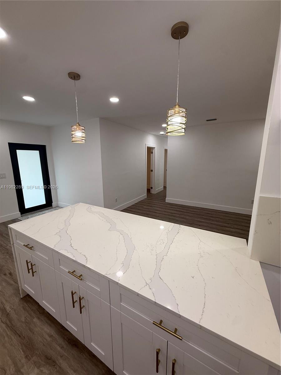 1014 West 66th Street Hialeah, FL 33012 - Photo 29 of 43 a large white kitchen with a large island sink and refrigerator