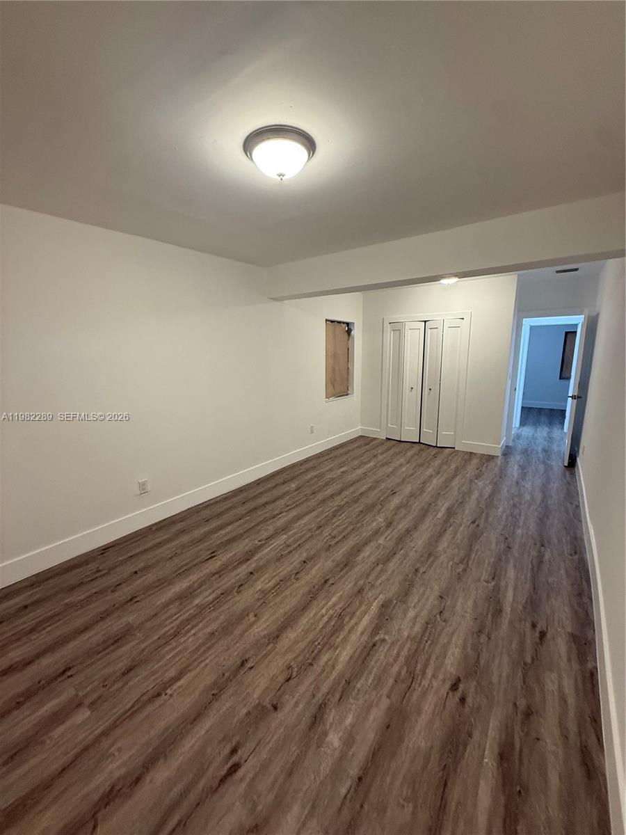 1014 West 66th Street Hialeah, FL 33012 - Photo 36 of 43 an empty room with wooden floor and windows