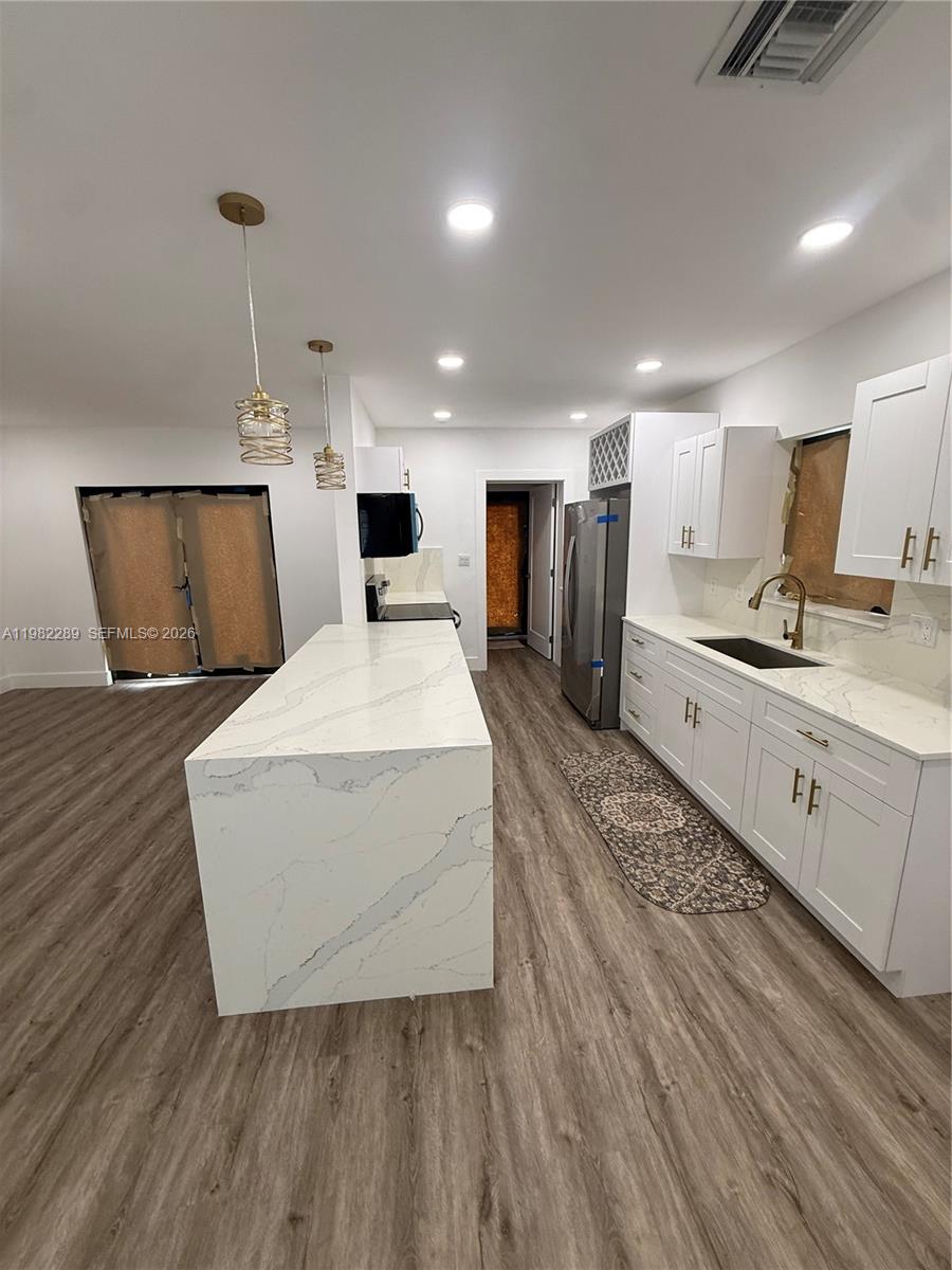 1014 West 66th Street Hialeah, FL 33012 - Photo 40 of 43 a large room with kitchen island a stove a sink dishwasher and a oven