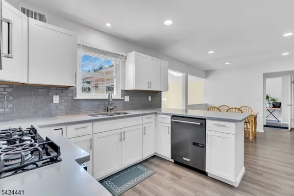 a kitchen with stainless steel appliances a stove a sink and a refrigerator
