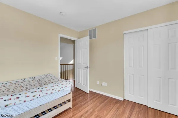 a bedroom with a bed and wooden floor