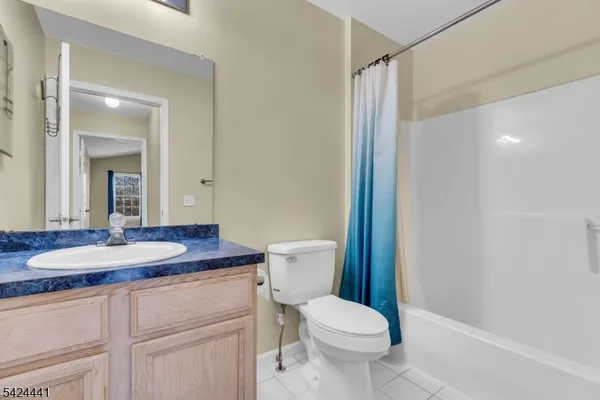 a bathroom with a granite countertop sink a toilet a mirror and shower
