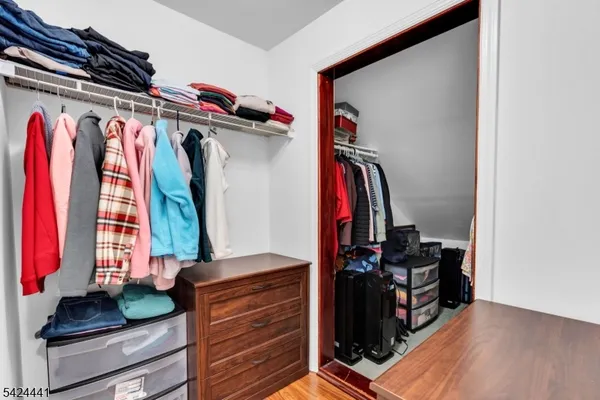 a view of walk in closet with clothes and shoes