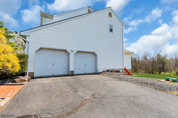a view of a white house with a yard and garage