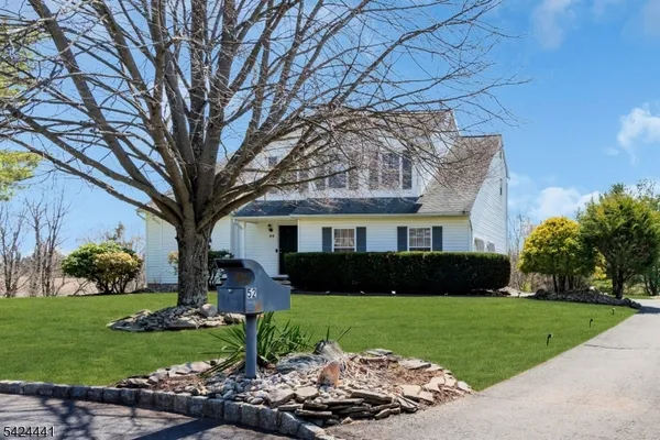 a front view of a house with a yard and potted plants