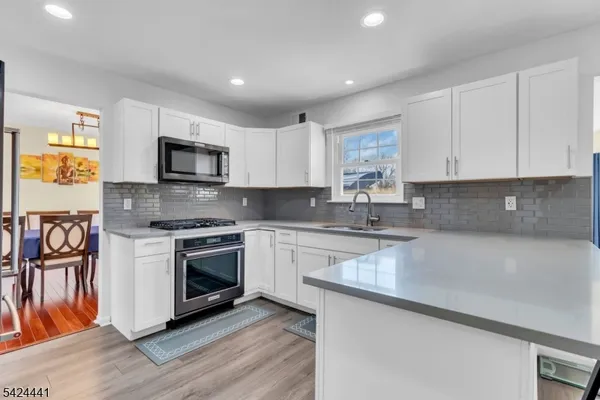 a kitchen with stainless steel appliances granite countertop a stove a sink and a microwave