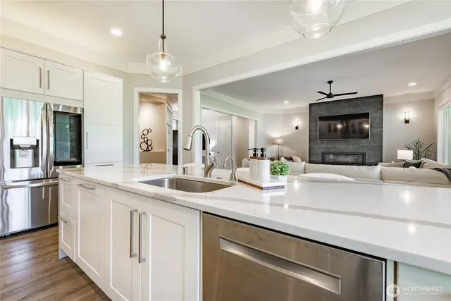a kitchen with stainless steel appliances granite countertop a sink and a refrigerator