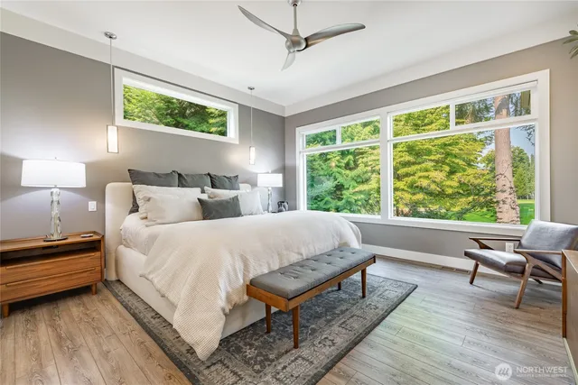 a spacious bedroom with a bed a couch and a large window