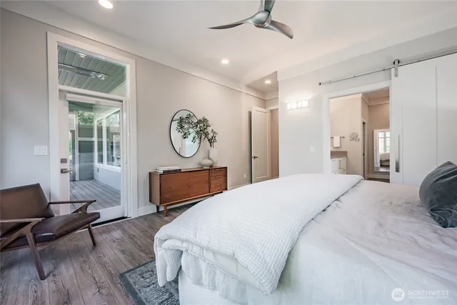 a bedroom with a bed a mirror and a window