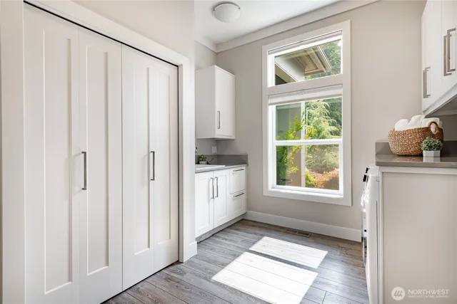 a kitchen with white cabinets and window