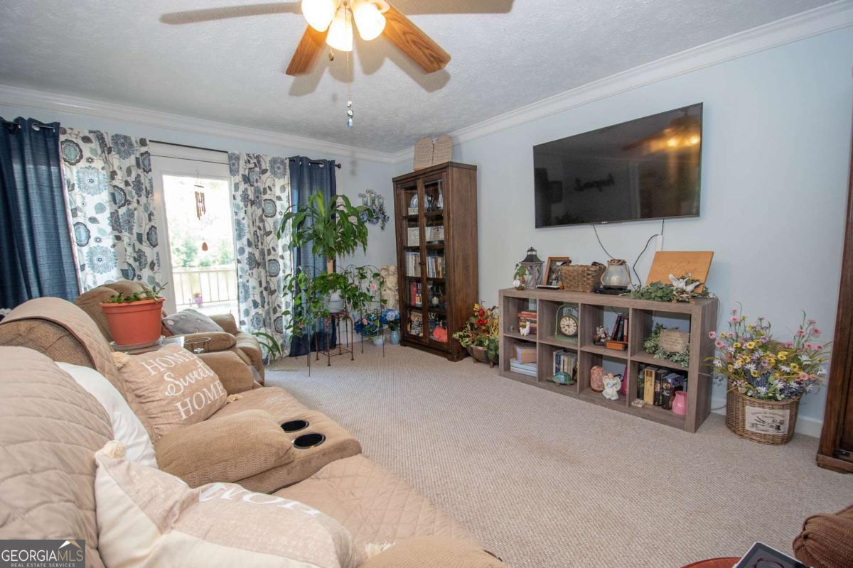 4973 Greenville Road LaGrange, GA 30241 - Photo 53 of 108 a living room with furniture a flat screen tv and a large window