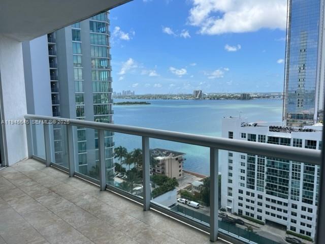 a view of a balcony with wooden floor & fence
