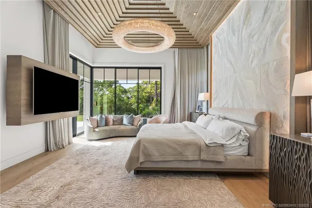 a spacious bedroom with a large bed a flat screen tv and a couch