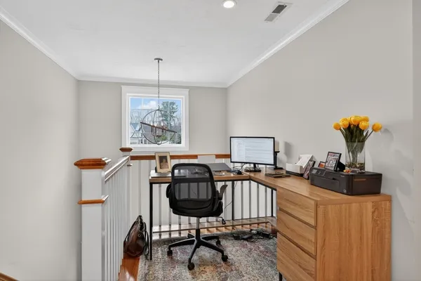 a view of a workspace with furniture and a window