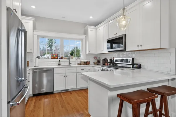 a kitchen with white cabinets and stainless steel appliances