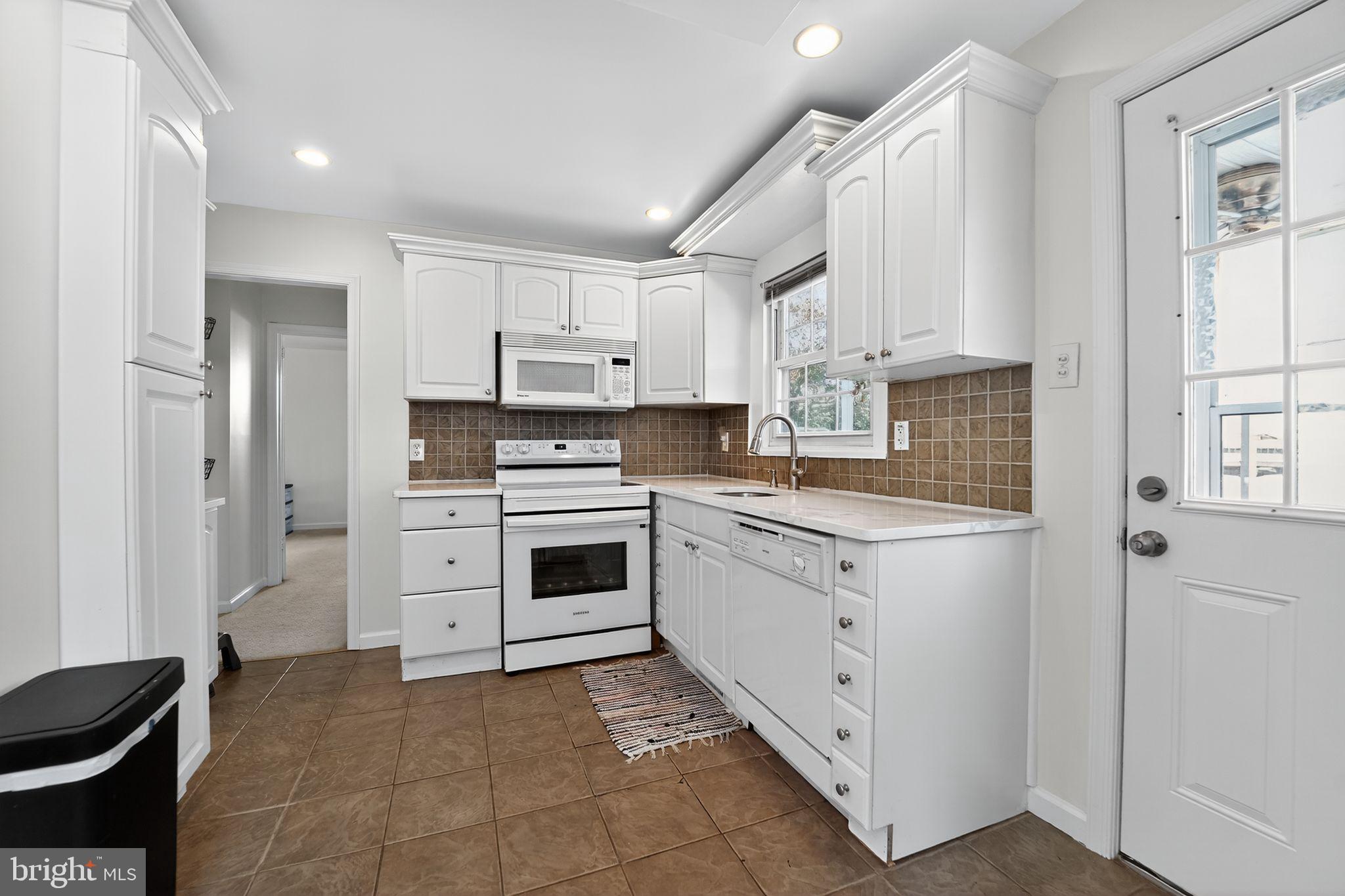 3127 Cornwall Road Baltimore, MD 21222 - Photo 8 of 24 a kitchen with white cabinets and white appliances