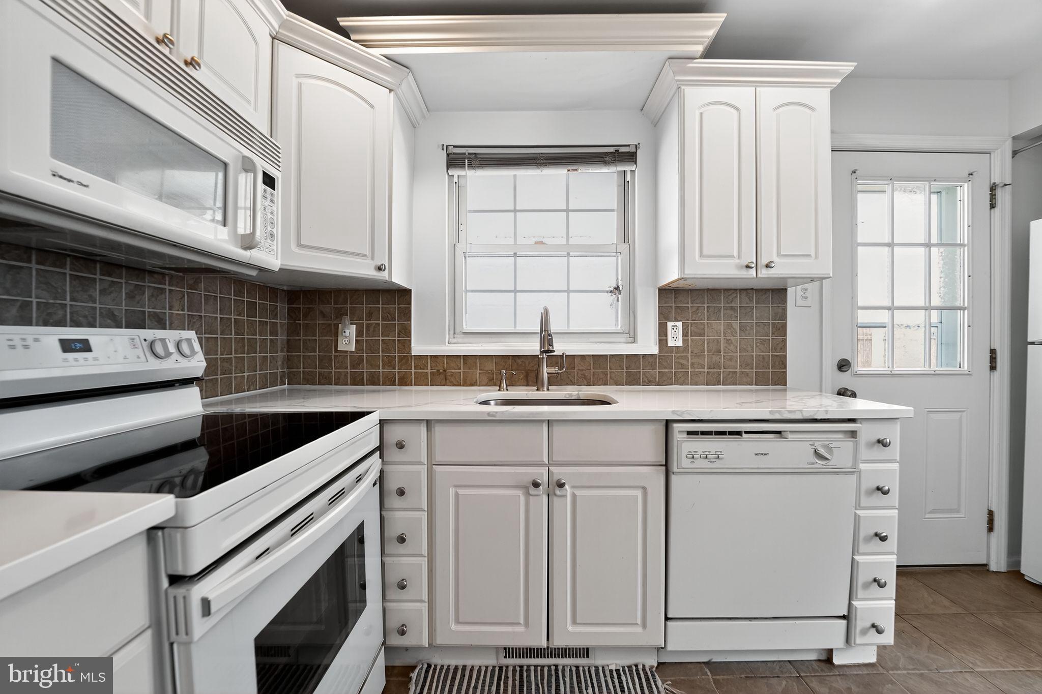 3127 Cornwall Road Baltimore, MD 21222 - Photo 9 of 24 a kitchen with cabinets appliances a sink and a window