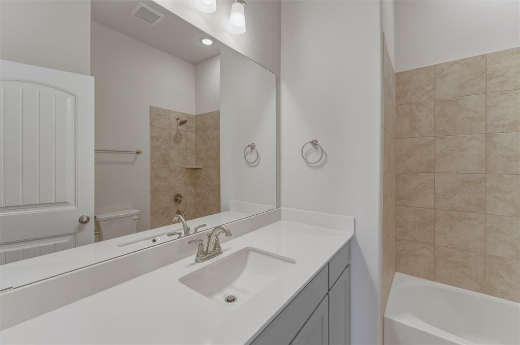 114 Hillview Trail Decatur, TX 76234 - Photo 19 of 27 Bathroom vanity featuring a single basin sink, brushed nickel faucet, large mirror, and light gray cabinetry