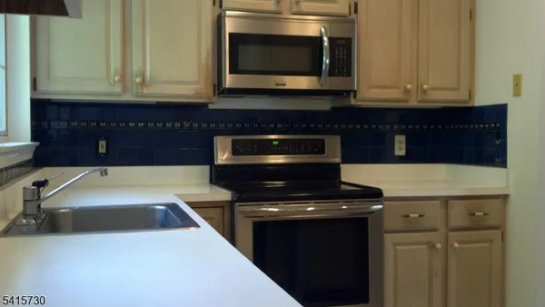 a kitchen with granite countertop a stove and a microwave
