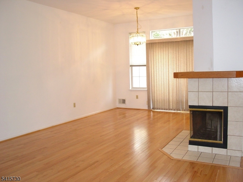 13 Wood Duck Pond Road Bedminster, NJ 07921 - Photo 7 of 13 a view of an empty room with wooden floor fireplace and a window