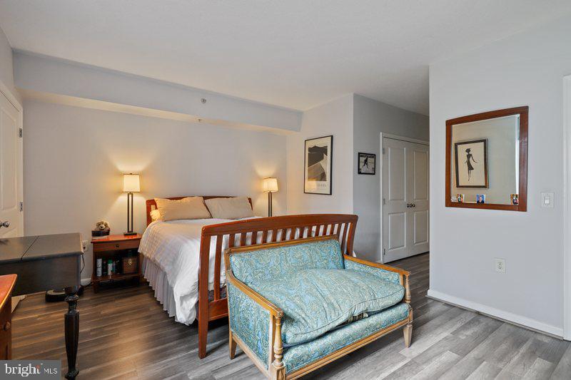 851 North Glebe Road, Unit 520 Arlington, VA 22203 - Photo 11 of 28 a bedroom with a bed paintings on the wall and a window