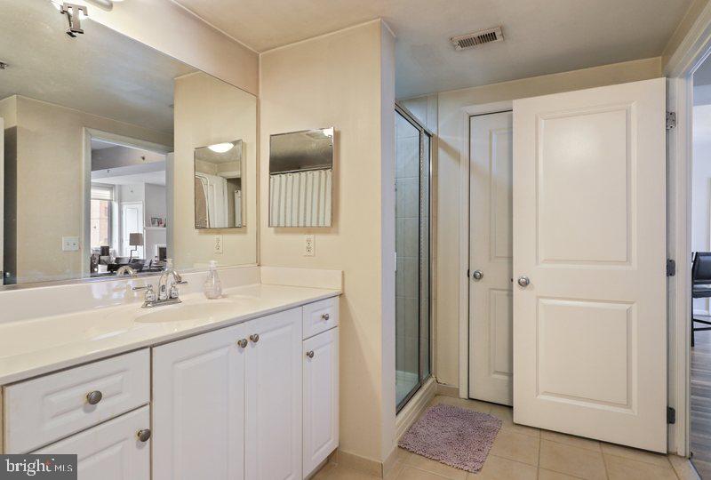 851 North Glebe Road, Unit 520 Arlington, VA 22203 - Photo 17 of 28 a bathroom with a sink a mirror a vanity and a shower