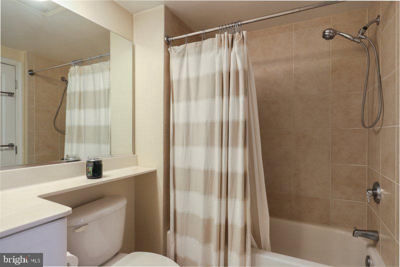 851 North Glebe Road, Unit 520 Arlington, VA 22203 - Photo 23 of 28 a bathroom with a granite countertop sink toilet and shower