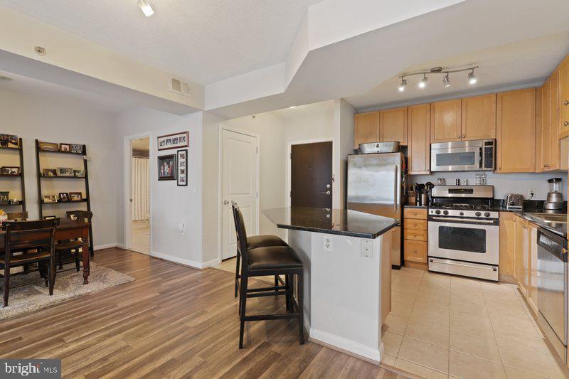 851 North Glebe Road, Unit 520 Arlington, VA 22203 - Photo 5 of 28 a kitchen with kitchen island a white cabinets and refrigerator